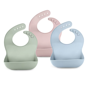 Trio of silicone baby bibs on white background.