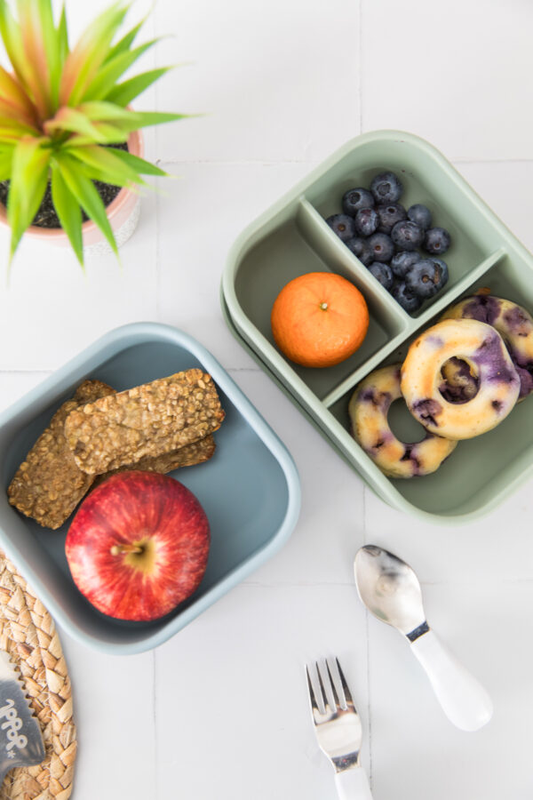 birds eye view of the Scrummy Tummies snack box next to the matching lunch box with food inside.